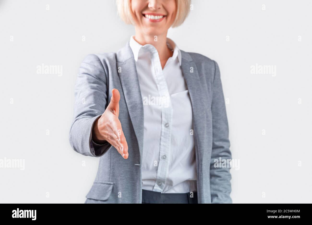 Unrecognizable mature lady boss out for handshake on light background, up Stock Photo - Alamy
