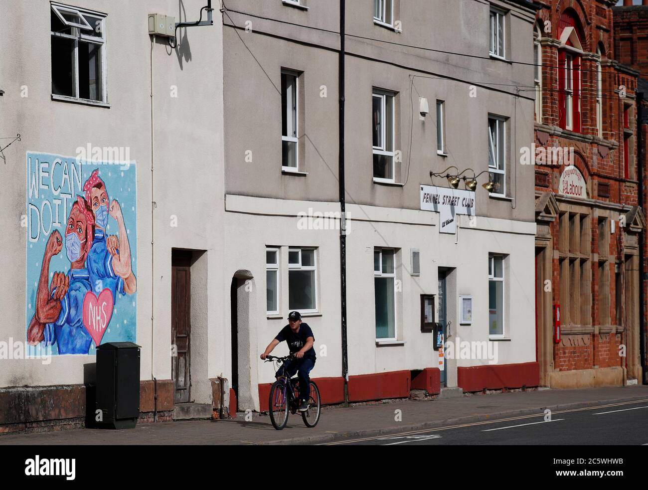 Loughborough, Leicestershire, UK. 5th July 2020. A man cycles past a mural paying tribute to the National Health Service on its 72nd anniversary during the coronavirus pandemic. Credit Darren Staples/Alamy Live News. Stock Photo