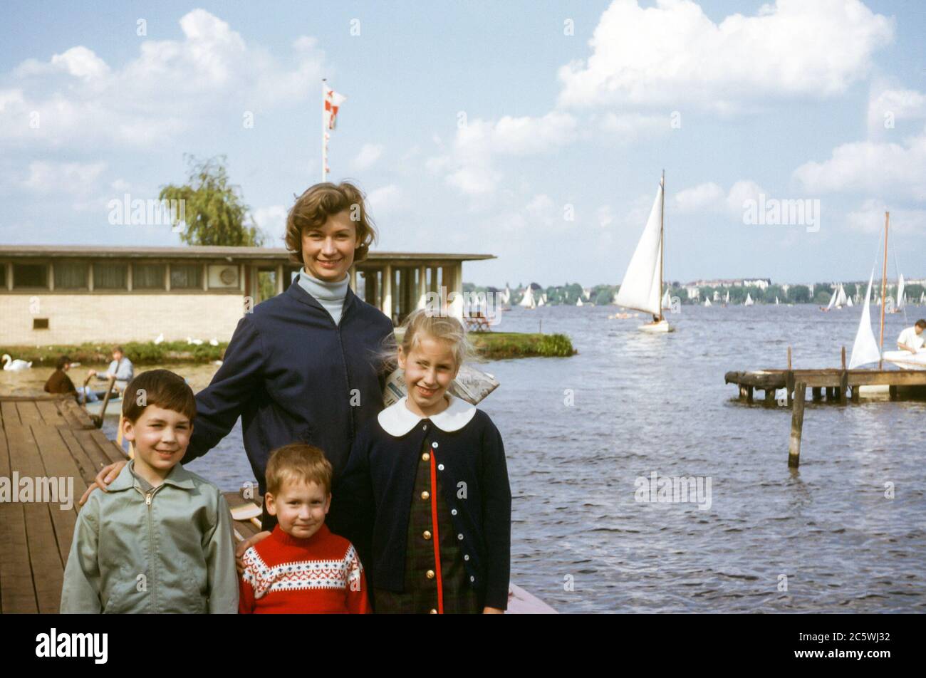 Family with mother and three children  on a pier at the Alster lake, Hamburg, Germany in the 1960s Stock Photo