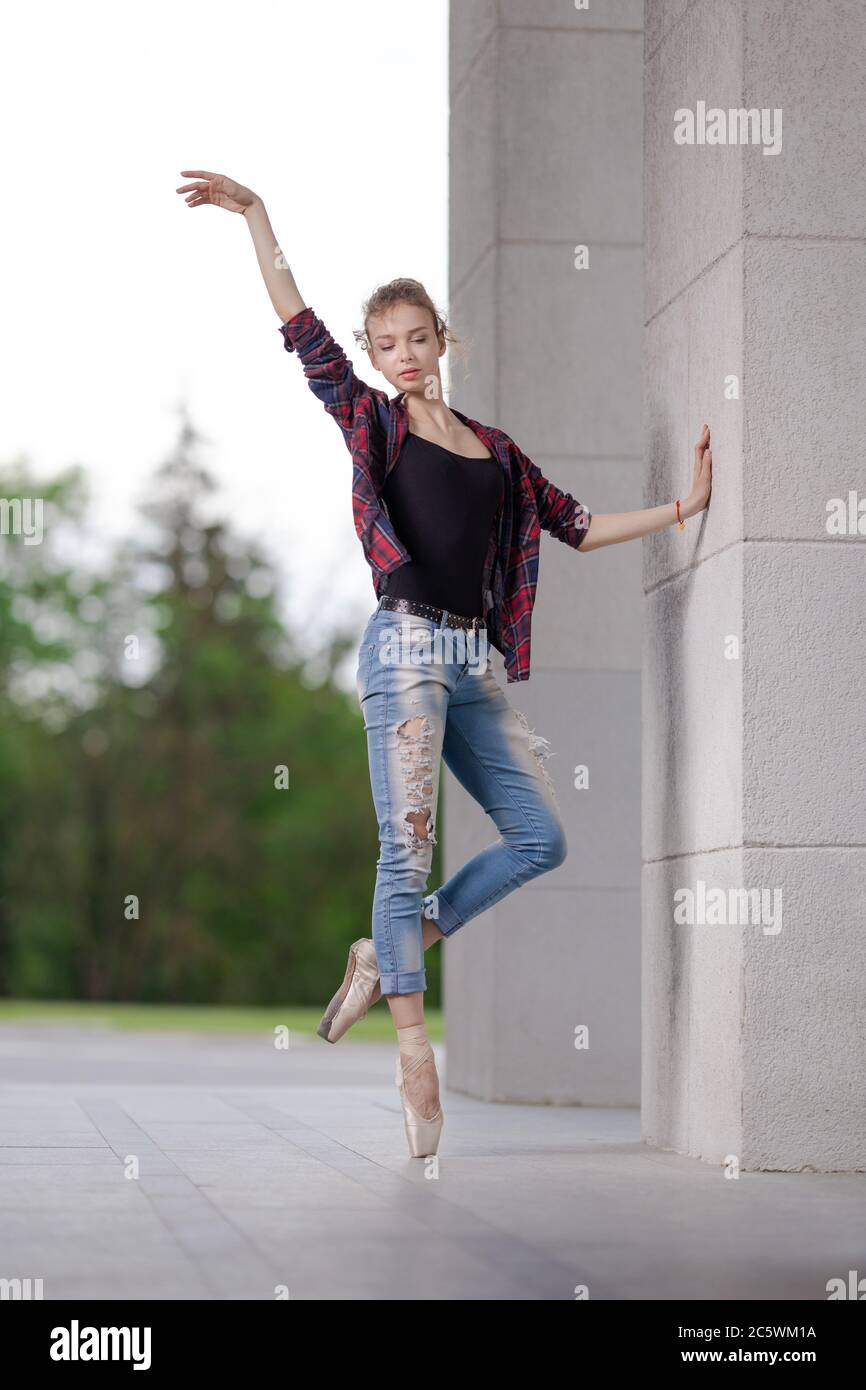 Girl ballerina in jeans, a plaid shirt and pointe shoes dancing in the city  on the street Stock Photo - Alamy