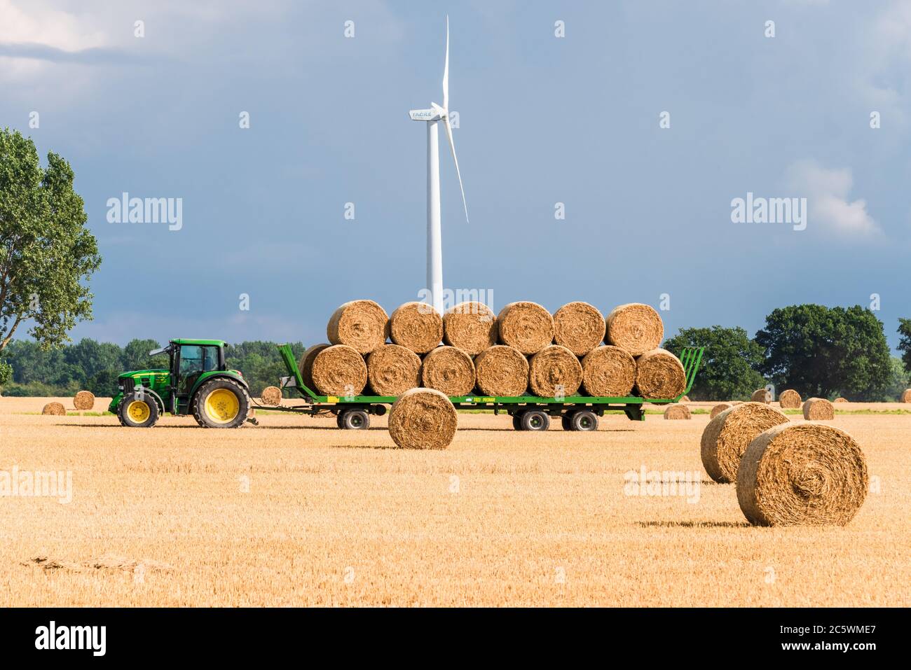 Windkraftanlagen auf einem Getreidefeld in Schleswig-Holstein während der Ernte in Herbst Stock Photo