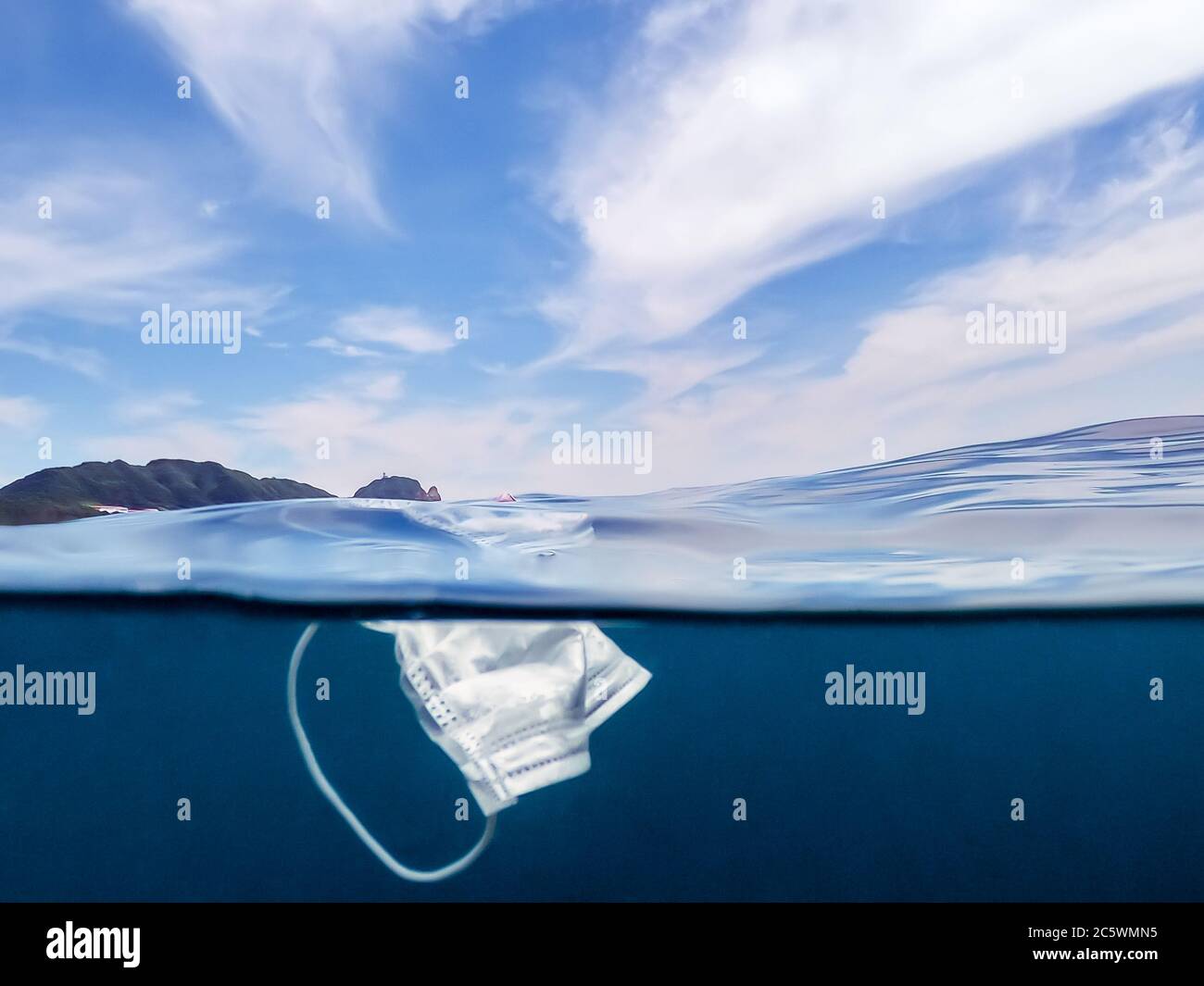 Protective mask discarded and thrown on the ocean. Abandoned facemask