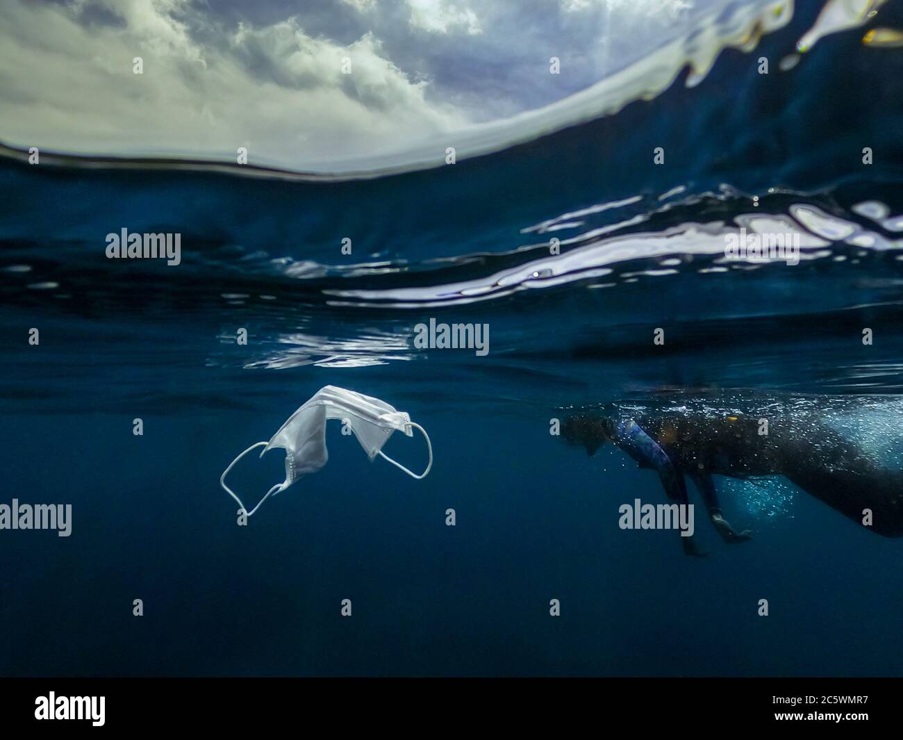 Waste during COVID19. Volunteer woman snorkeler diving underwater and cleaning up the ocean