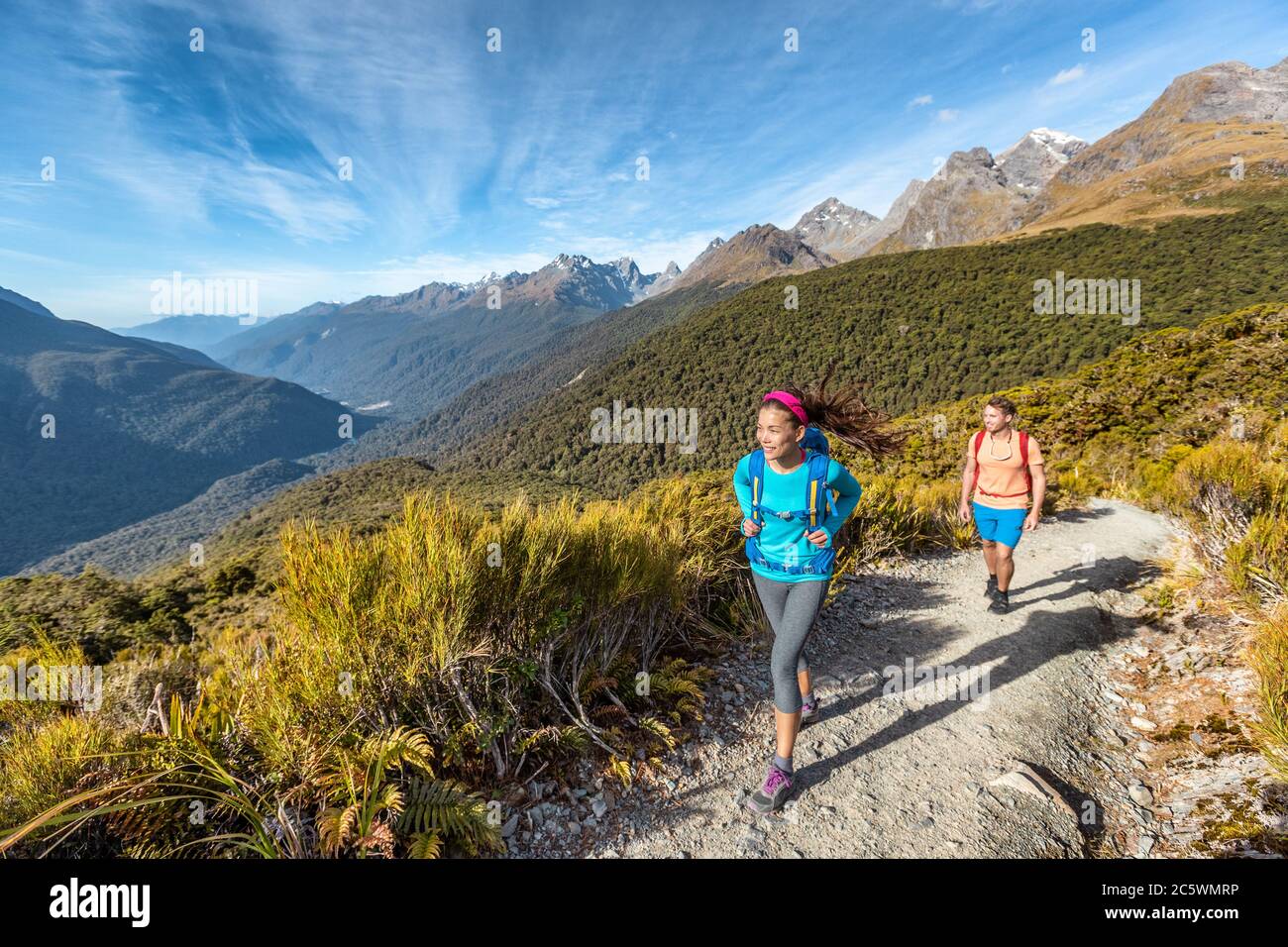 Hiking couple walking on trail at Routeburn Track during sunny day. Male and female hikers are tramping on Key Summit Track. travelling in Fiordland Stock Photo