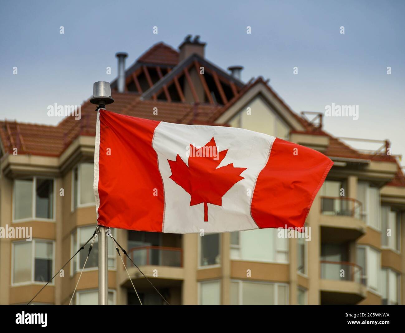 KELOWNA, BRITISH COLUMBIA, CANADA - JUNE 2018: Canadian national flag flying in front of a building in Kelowna, BC. Stock Photo