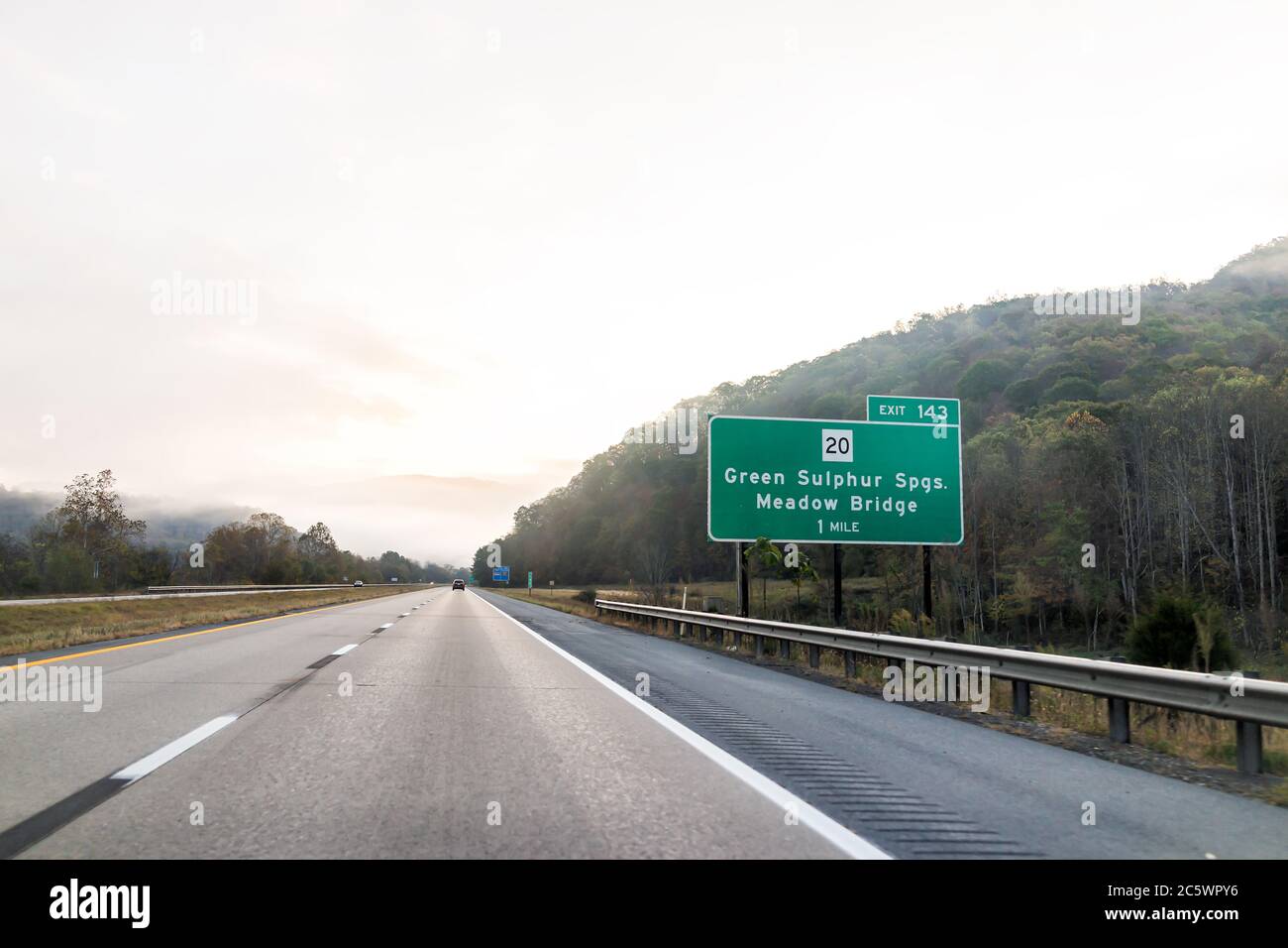 Green Sulphur Springs, USA - October 18, 2019: Fog mist road highway 64 driving in rural countryside in West Virginia with cars in traffic in morning Stock Photo