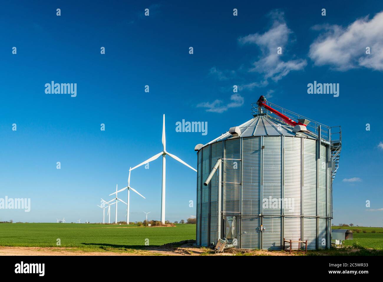 Windmühlen und Biogasanlage auf einem Bauernhof in Schleswig-Holstein Stock Photo