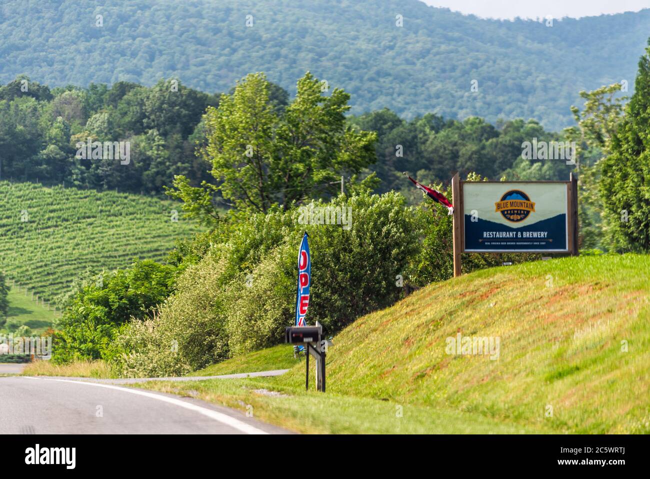 Afton, USA - June 9, 2020: Nelson County, Virginia countryside with road sign for Blue Mountain brewery tasting room open Stock Photo