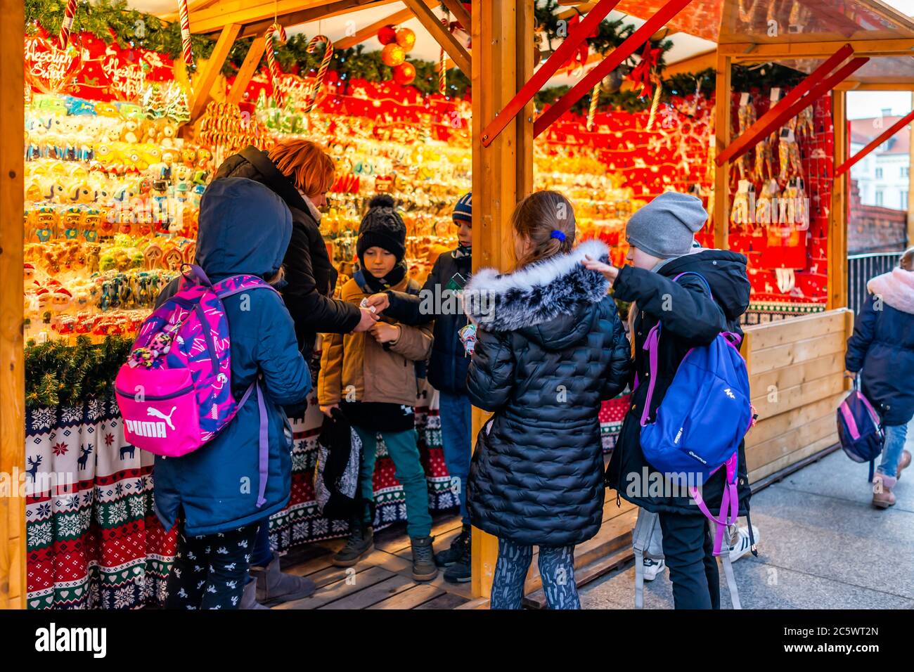 Warsaw, Poland - December 19, 2019: Old town Warszawa Christmas market selling candy sweets and group of young children kids people shopping wanting f Stock Photo