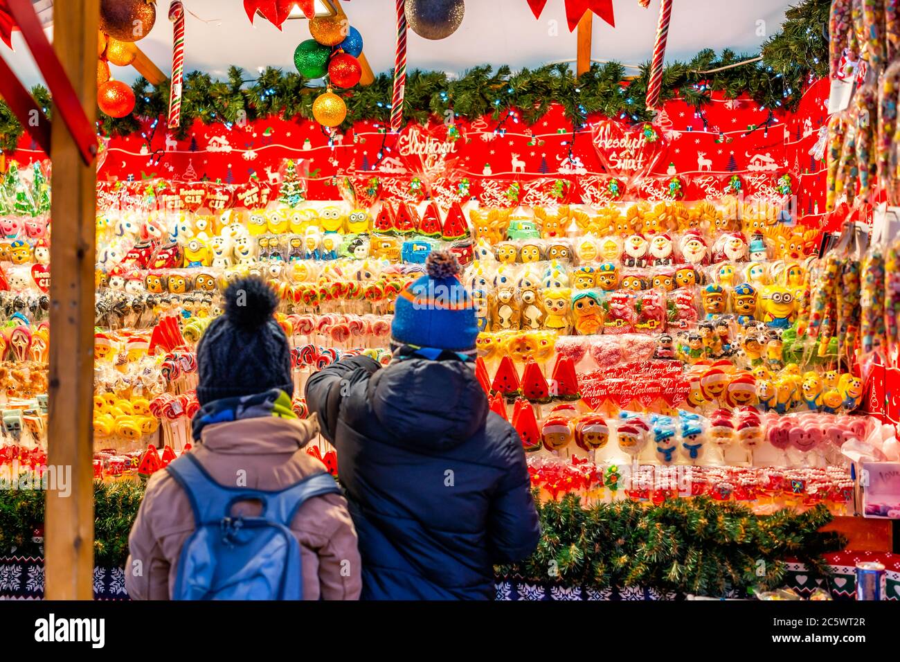 Warsaw, Poland - December 19, 2019: Old town Warszawa Christmas market selling candy sweets and young children kids people shopping wanting food Stock Photo