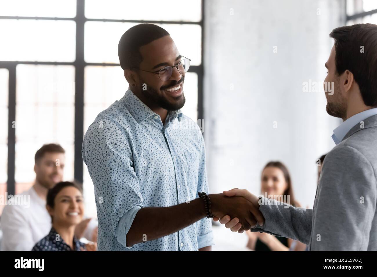 African employee got promotion feels happy shake hands with boss Stock