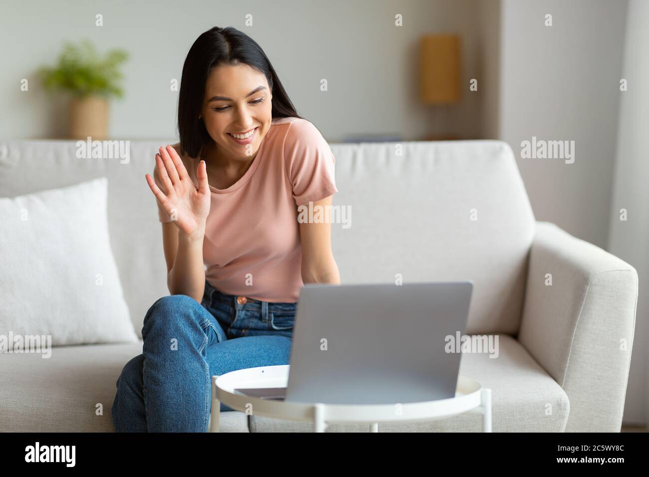 Girl Making Video Call Using Laptop Sitting On Sofa Indoors Stock Photo ...