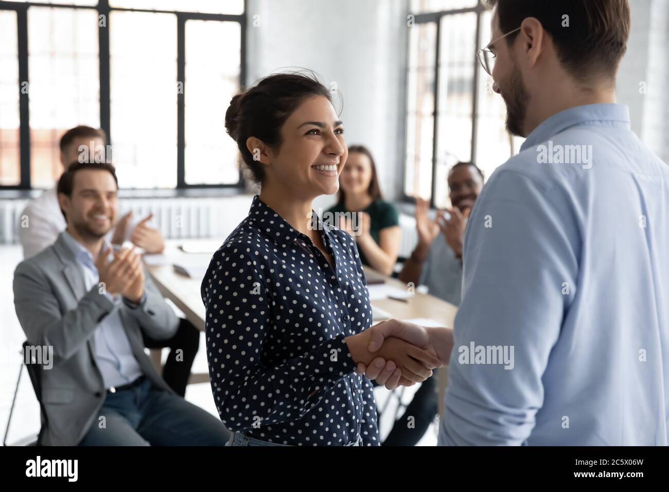 Happy Indian employee get promotion receive praises handshake with boss Stock Photo
