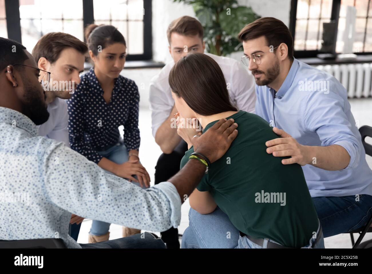 Members supporting caucasian female rehab session participant Stock Photo
