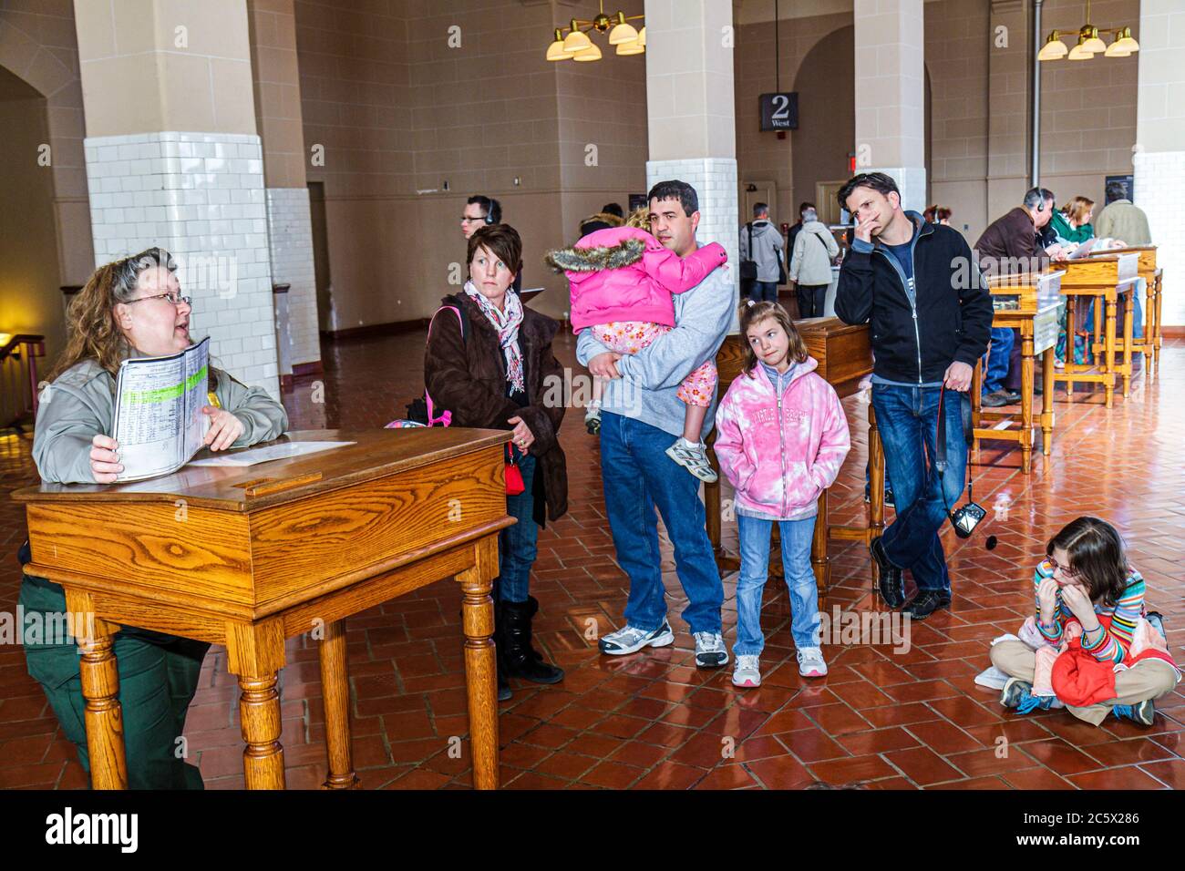 New York,New York City,NYC,Statue of Liberty National Monument,Ellis Island Immigration Museum,historic site,Great Hall,processing desk,man men male a Stock Photo