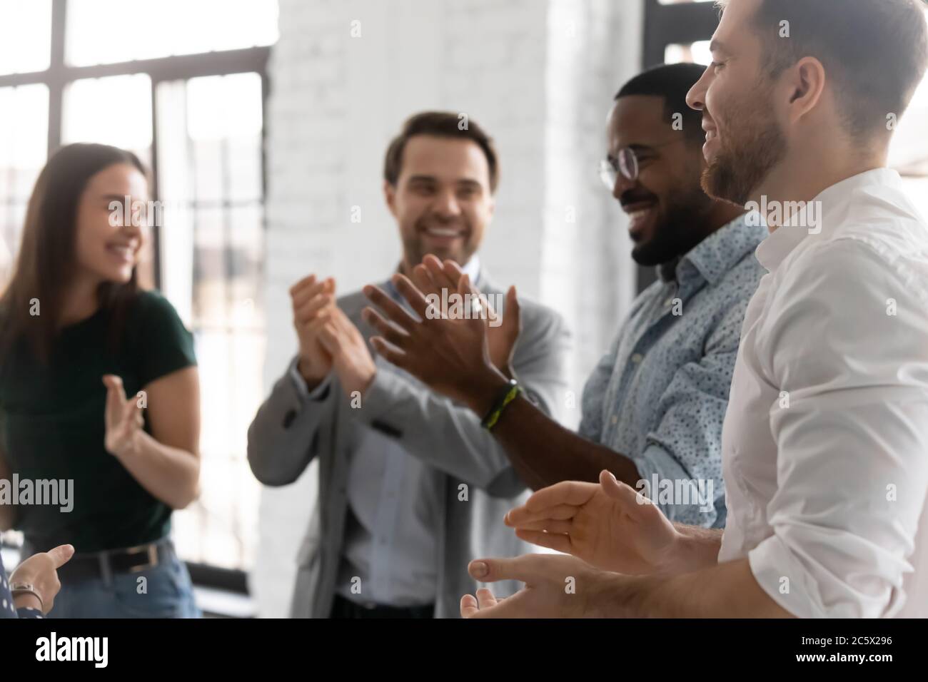 Enthusiastic businesspeople clap hands congratulating each other with common success Stock Photo