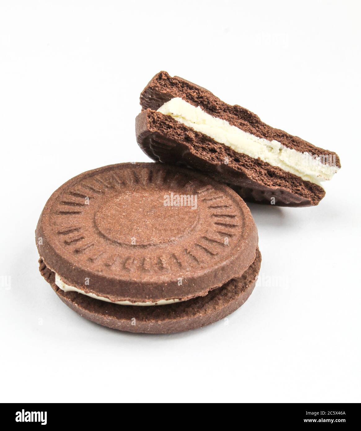 Filled tea biscuits isolated on white background. Chocolate sandwich cookie with milk filling cracked Stock Photo