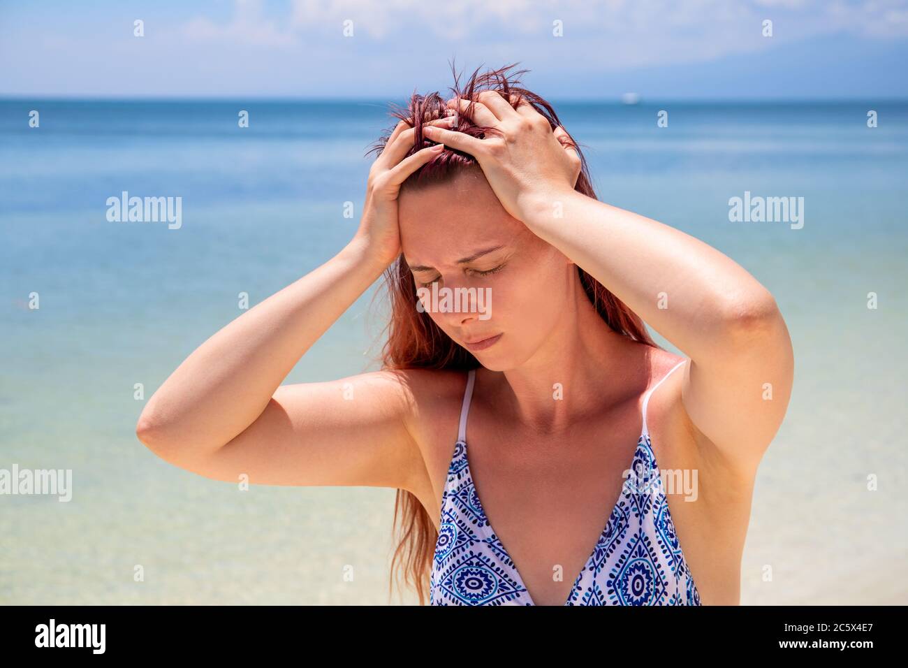 Sunstroke headache on tropic seaside during vacation. Bright sun ...