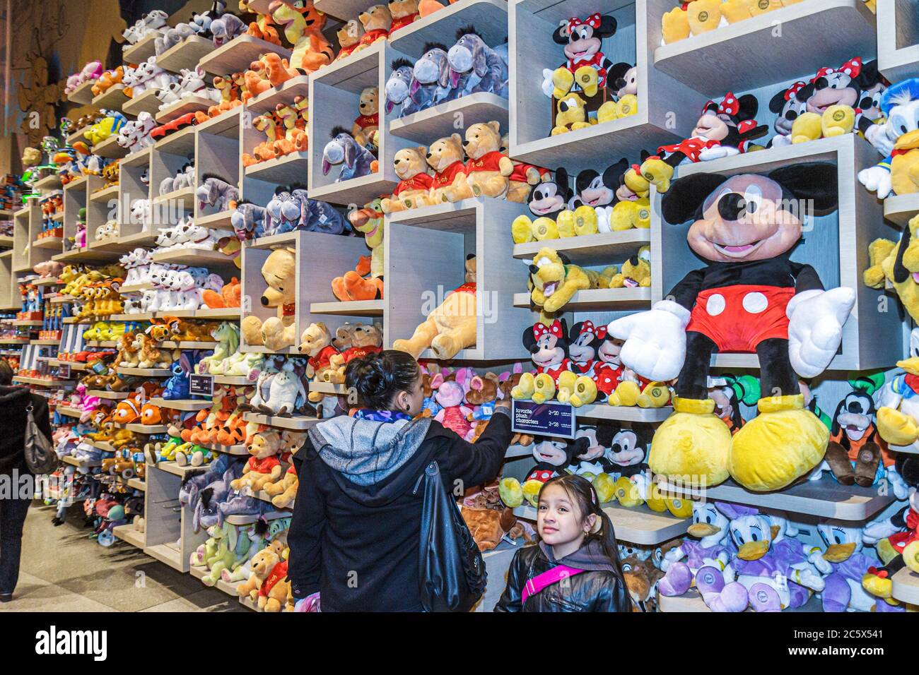 New York City,Manhattan,Times Square Disney Store,movie characters display sale stuffed dolls toys,Hispanic girl mother parent daughter Mickey Mouse Stock Photo