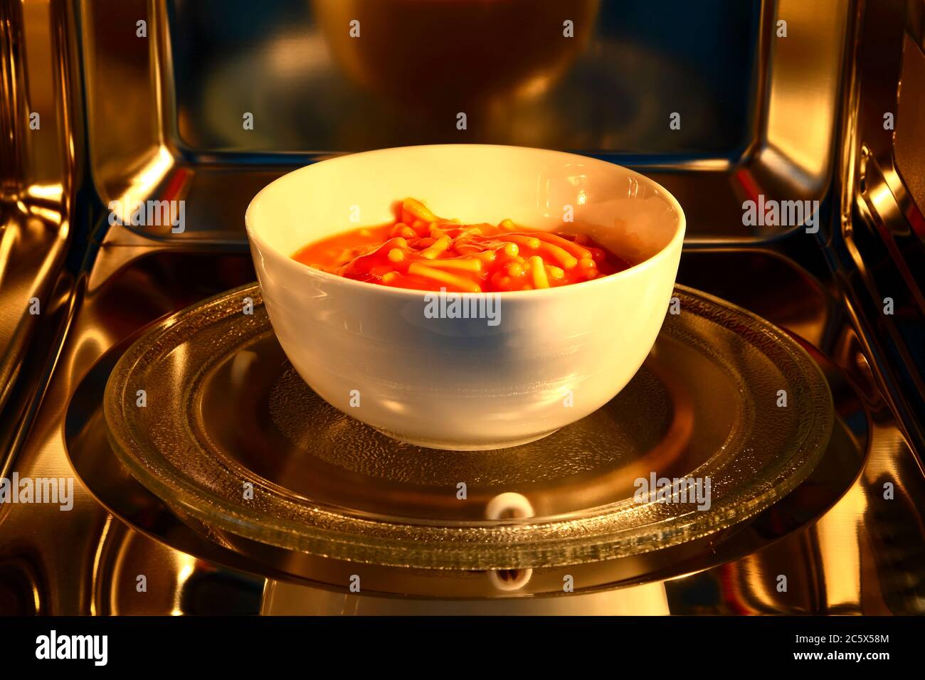 https://c8.alamy.com/comp/2C5X58M/bowl-of-spaghetti-pasta-inside-the-cavity-of-a-stainless-steel-microwave-oven-2C5X58M.jpg