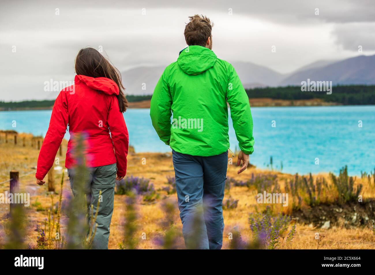 New Zealand travel - couple tourists looking at nature view of Lake Pukaki hiking near Aoraki aka Mount Cook at Peter's lookout, a famous tourist dest Stock Photo