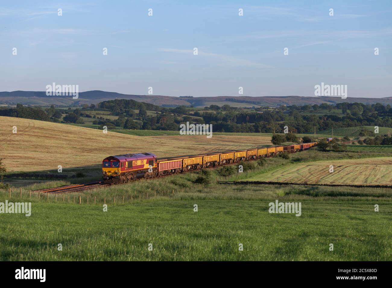 DB Cargo rail class 66 66025 locomotive passing Paythorne, Lancashire with a Network Rail engineers train Stock Photo