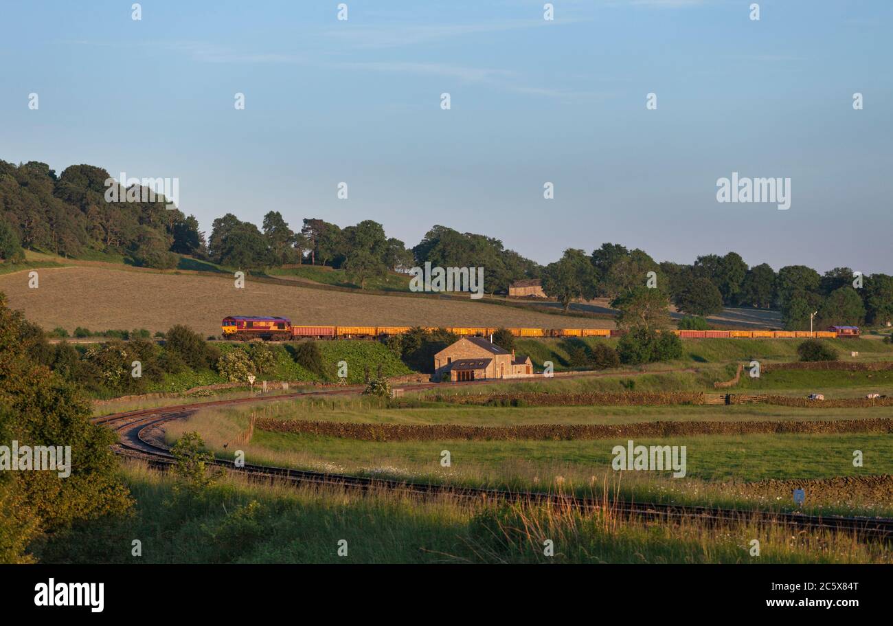 DB Cargo rail class 66 66025 locomotive passing Settle junction with a Network Rail engineers train Stock Photo