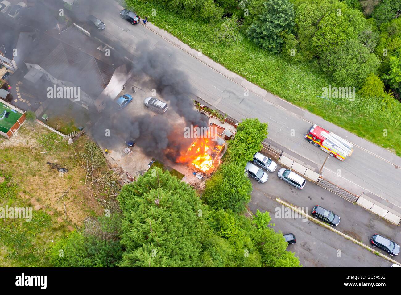 Aerial view of firefighters tackling a small blaze in a domestic outbuilding. The fire was extinguished within minutes Stock Photo