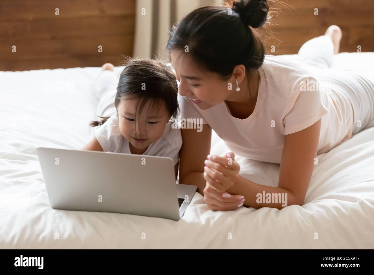Cute asian baby girl using computer with mommy. Stock Photo