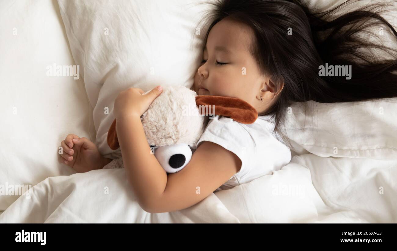Charming cute little asian ethnic girl baby sleeping in bed. Stock Photo