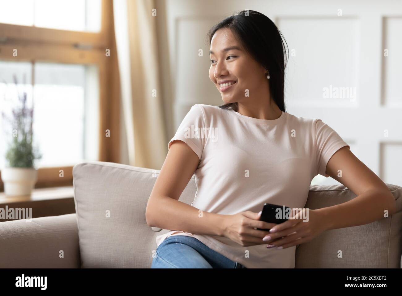 Happy young asian attractive lady dreaming of future. Stock Photo