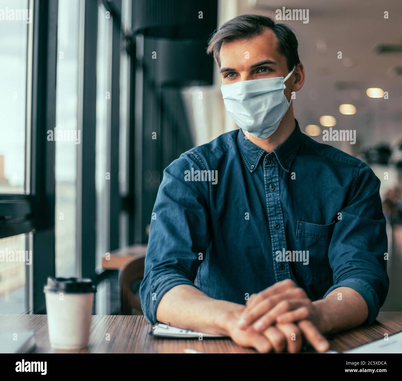 business colleagues in protective masks working with financial documents. Stock Photo