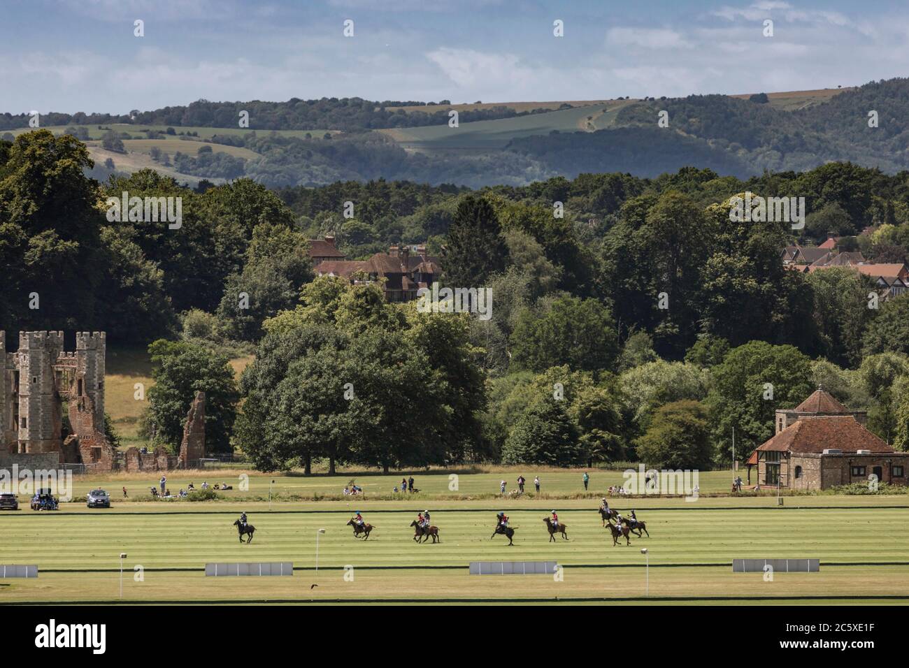 Les Lions play Scone (wearing red) at Cowdray Park Polo Club in Midhurst, Sussex in the early stages of the prestigious Gold Cup tournament. The polo Stock Photo