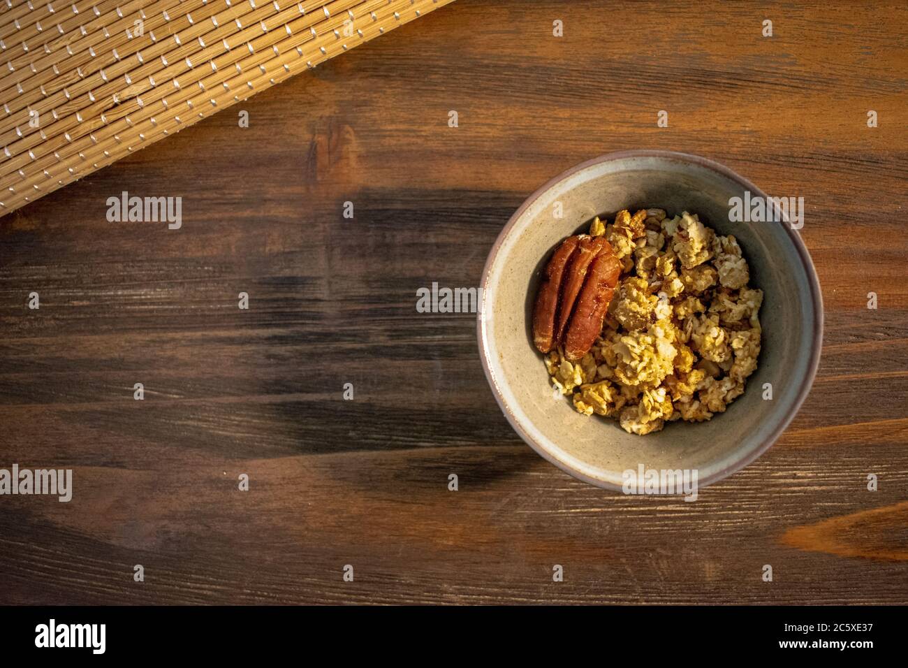 Top view of healthy food, granola bowl with pecan in wooden background and copy space Stock Photo