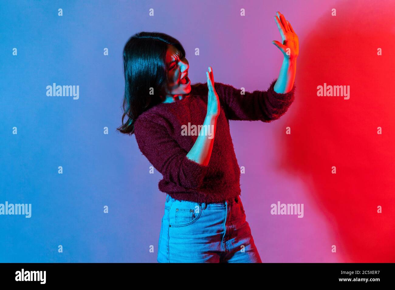 I am afraid! Side view, portrait of scared woman standing with raised  hands, hiding from fear and screaming in horror, looking frightened as  notices s Stock Photo - Alamy
