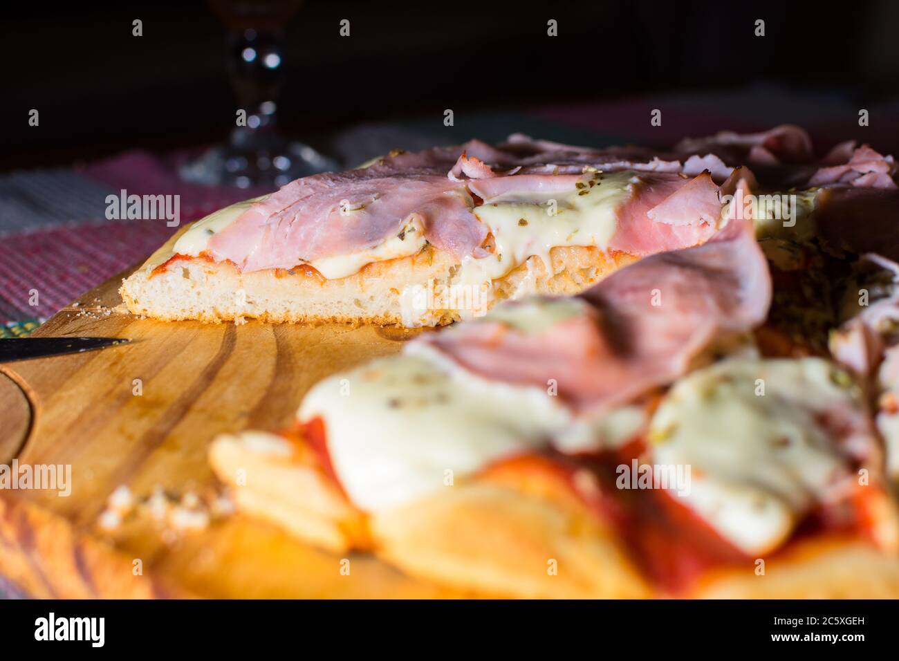 Ham and mozzarella pizza cut on wooden tray Stock Photo