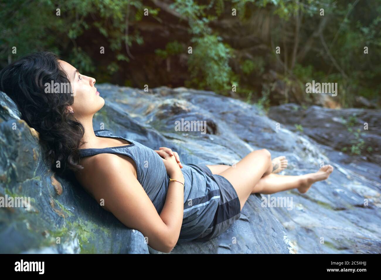 Resting On Rocks Woman lying on a rock resting Stock Photo - Alamy
