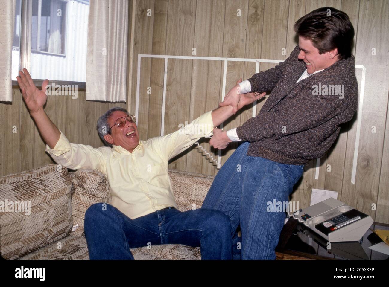 A young Jim Carrey acting out with his agent buddy Morra in his trailer on a movie lot circa 1984. Stock Photo