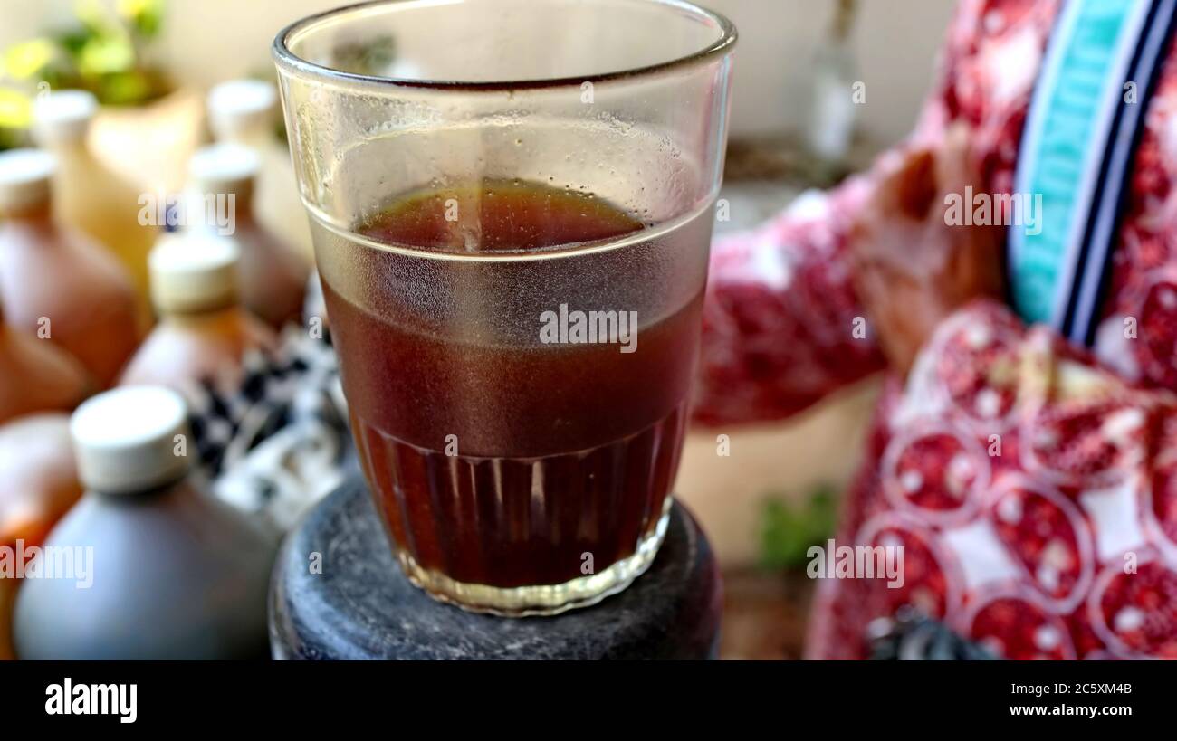 Traditional herbal medicine seller when brewing jaunya drink in a glass