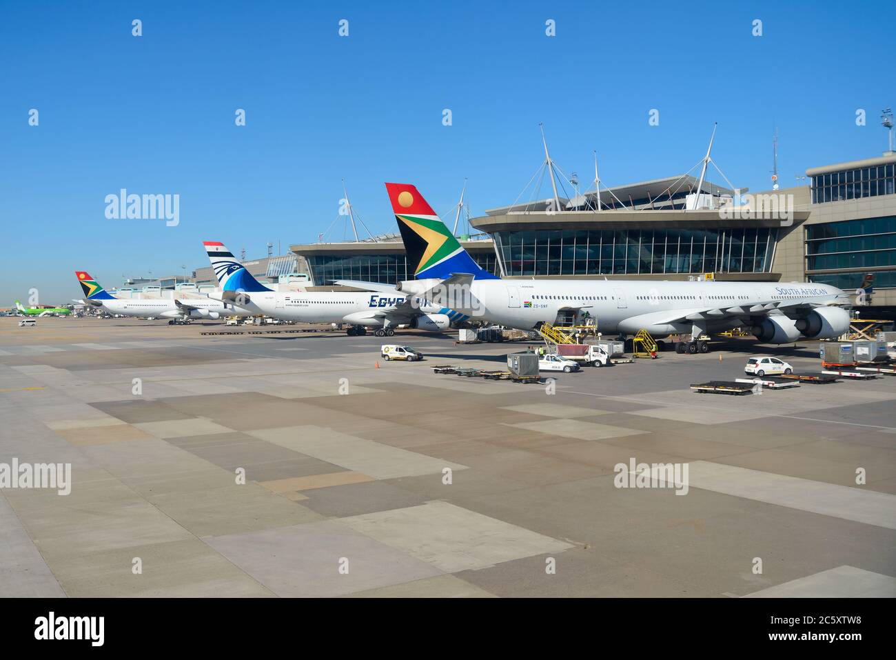 South African Airways and Egyptair aircraft parked at Johannesburg O R Tambo International Airport passengers terminal. Air travel in South Africa. Stock Photo