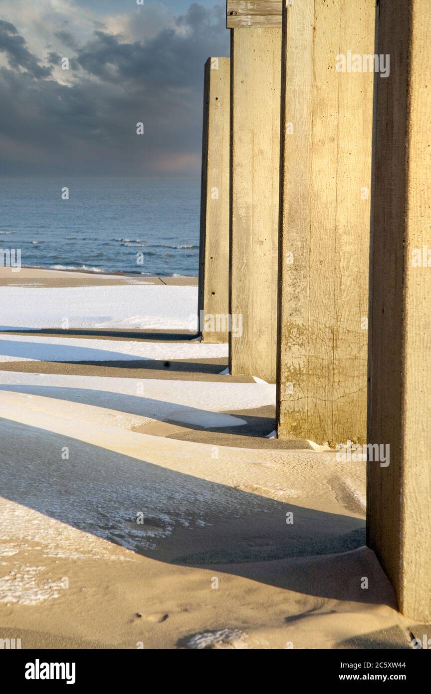 Sunlight through cement walls on a winter beach create a pretty abstract Stock Photo