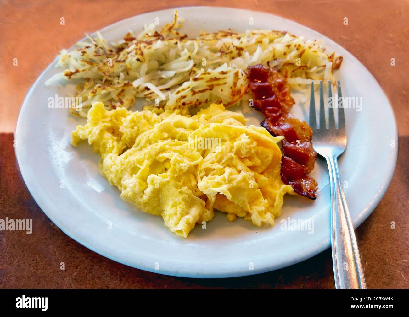 Scrambled Eggs With Bacon And A Side Of Crispy Hash Brown Potatoes For A Quick And Hearty Breakfast Stock Photo Alamy Scrambled Eggs With Bacon And A Side Of Crispy Hash Brown Potatoes For A Quick And Hearty Breakfast Stock Photo Alamy