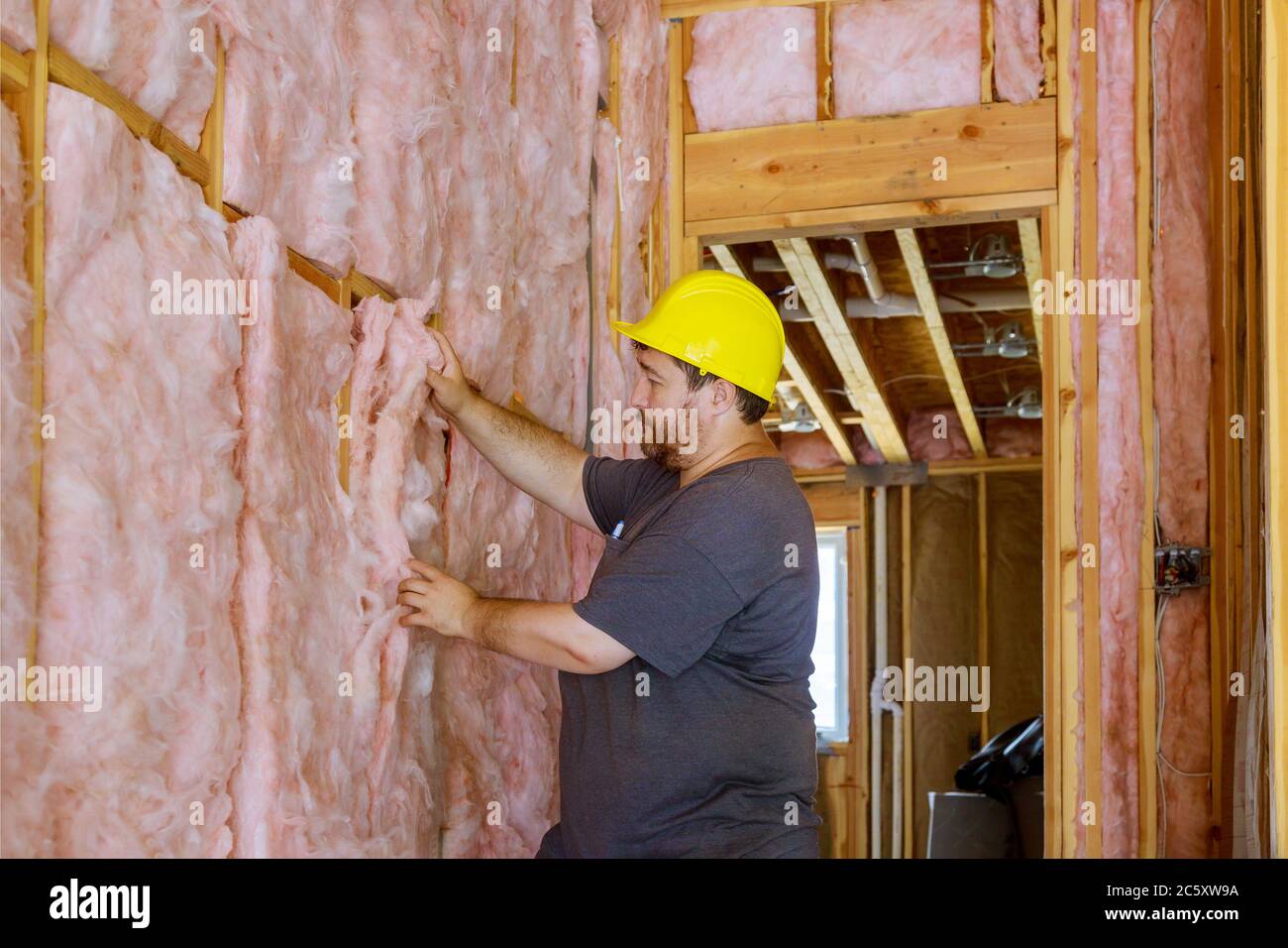 Man installing thermal insulation layer under the wall using mineral