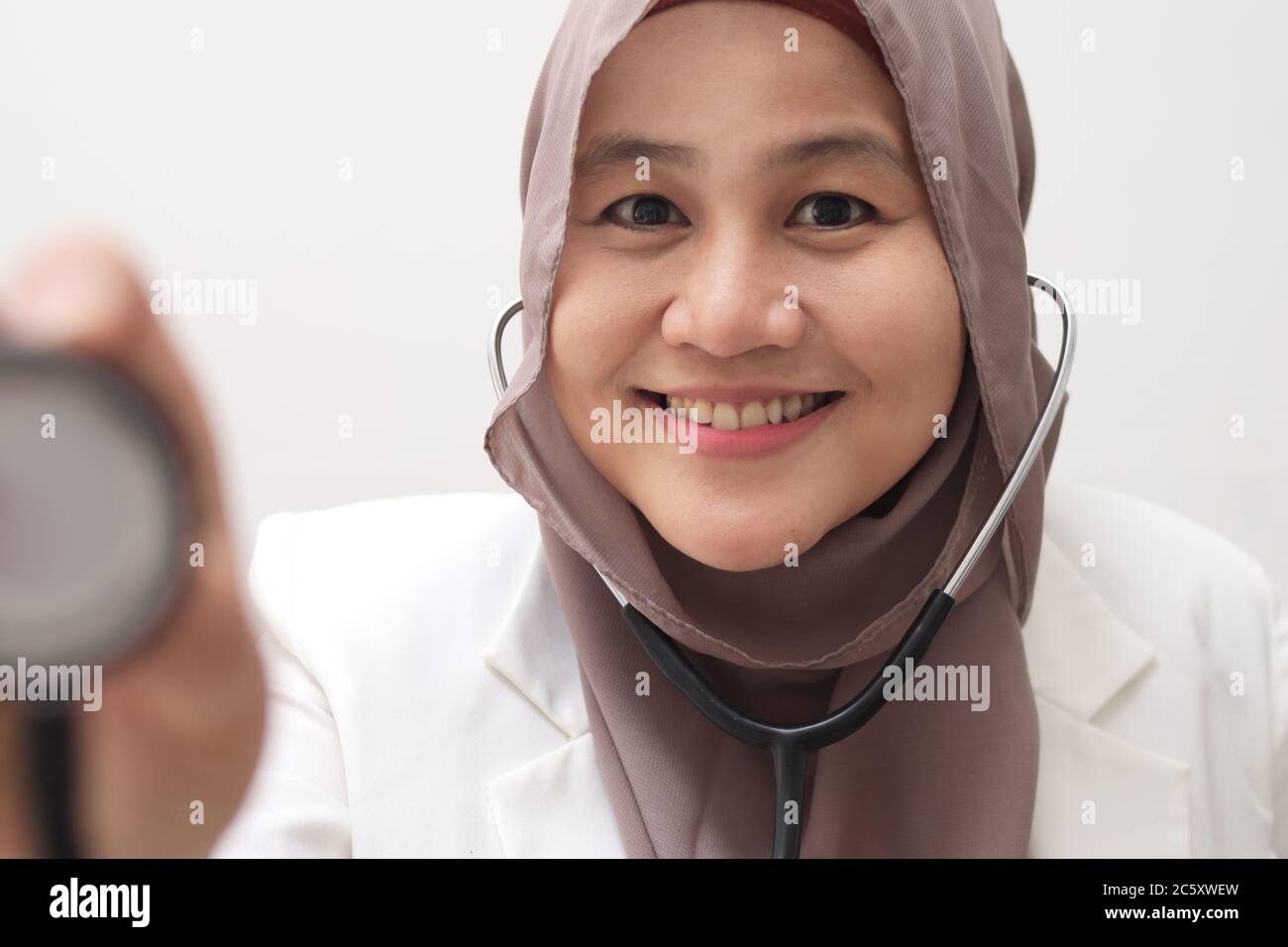 Beautiful Asian muslim female medical doctor wearing hijab want to make examination with