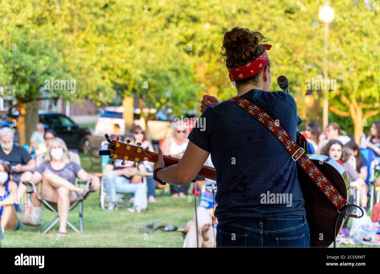 McGowan Park Summer Concerts - Sandy Stones Trio Band - Woman playing guitar in front of crowd in public park Stock Photo