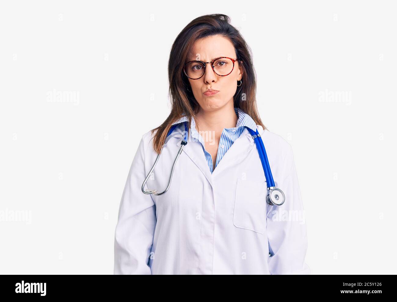 Young beautiful woman wearing doctor stethoscope and glasses depressed ...