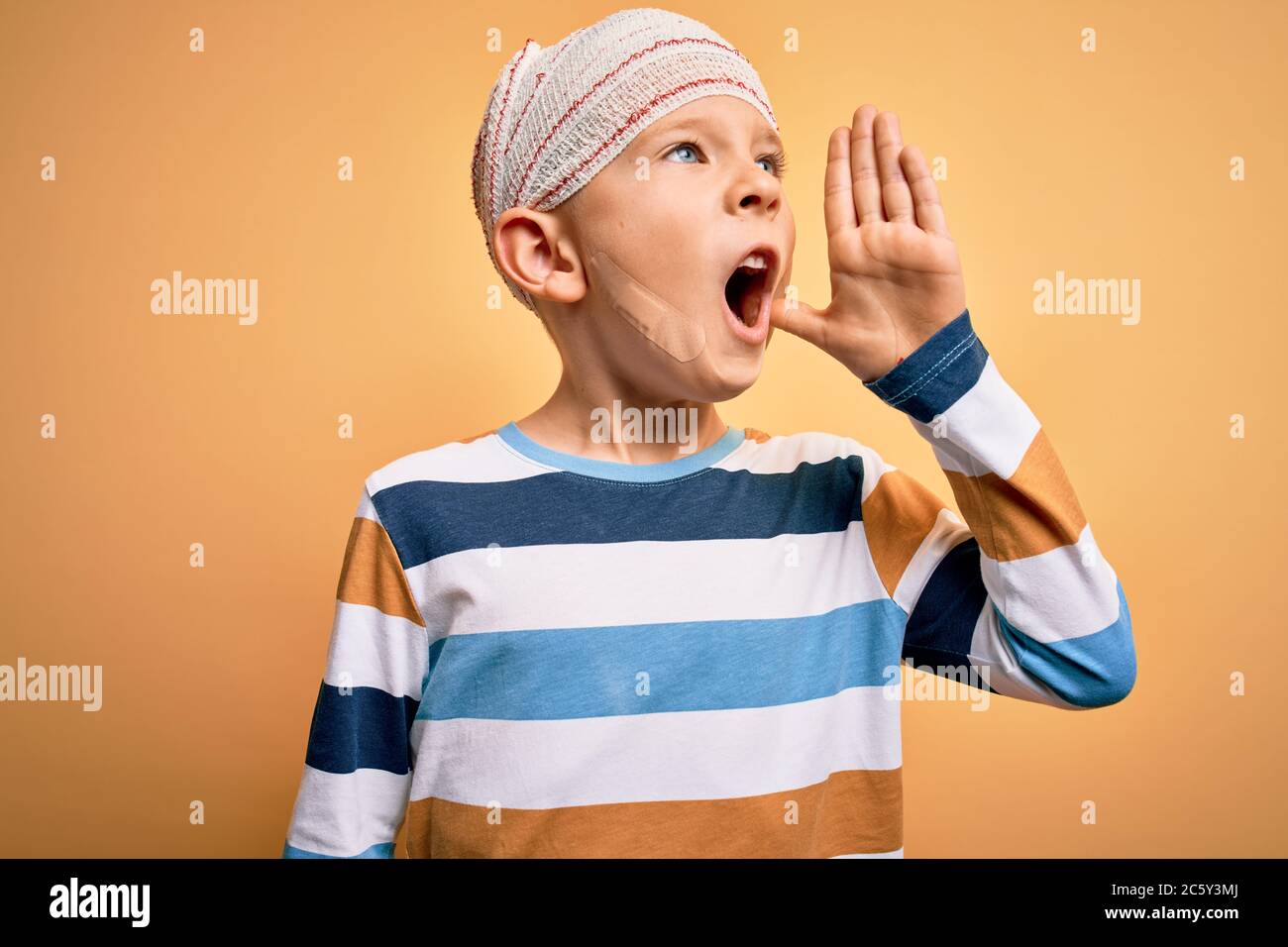 Young little caucasian kid injured wearing medical bandage on head over ...