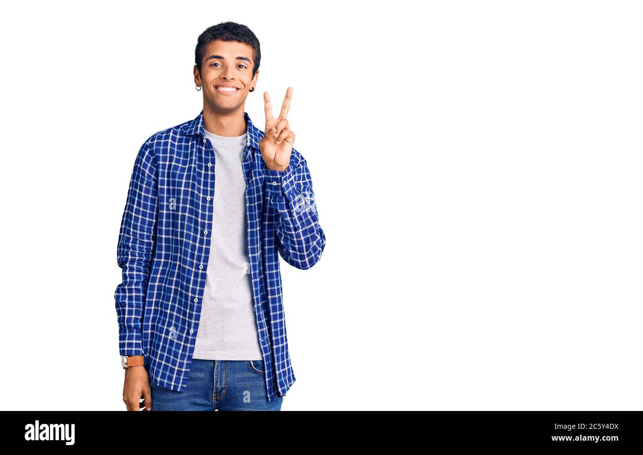 Young african amercian man wearing casual clothes smiling looking to the camera showing fingers doing victory sign. number two. Stock Photo