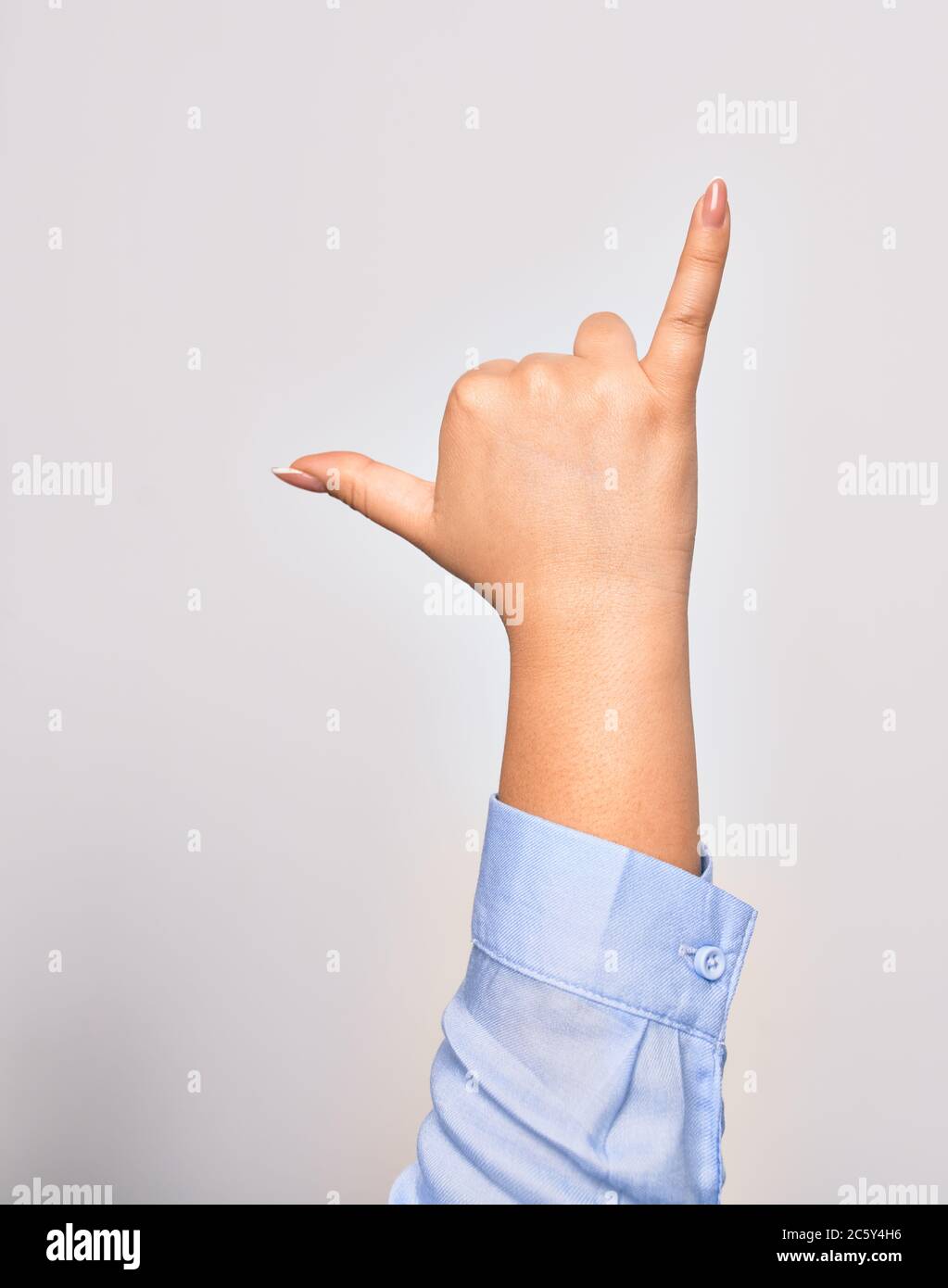 Hand of caucasian young woman doing surf salutation. Showing fingers doing telephone sign over isolated white background Stock Photo