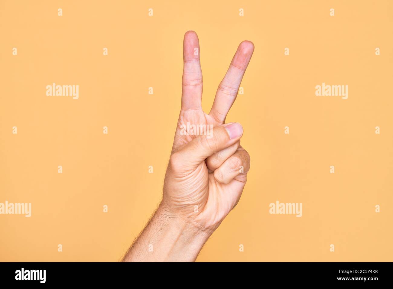 Hand of caucasian young man showing fingers over isolated yellow ...